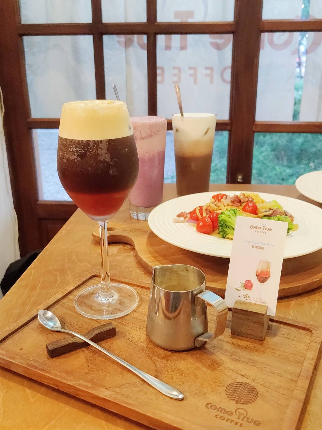 精品配方豆以全自動-高壓萃取而成，口感厚實帶有烤堅果及巧克力香氣，再加入氮氣讓口感有如生啤酒般的綿密滑順，搭配玫瑰荔枝果醬，入口先感受到荔枝的甜伴隨玫瑰清香，最後是咖啡的甘醇，口感清甜。